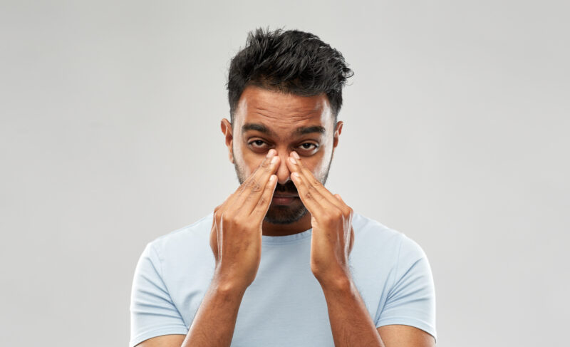 Man hold his nose, suffering from Nasal Congestion