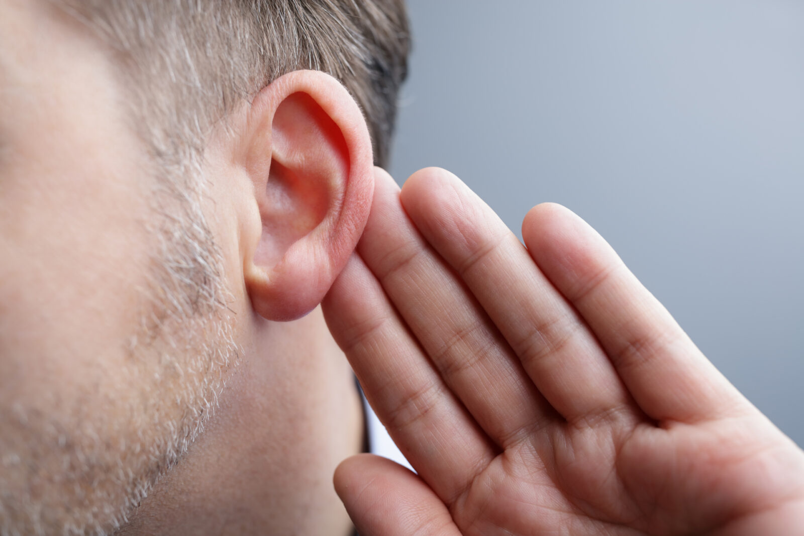 Person holds ear out to see if they have Sudden Hearing Loss