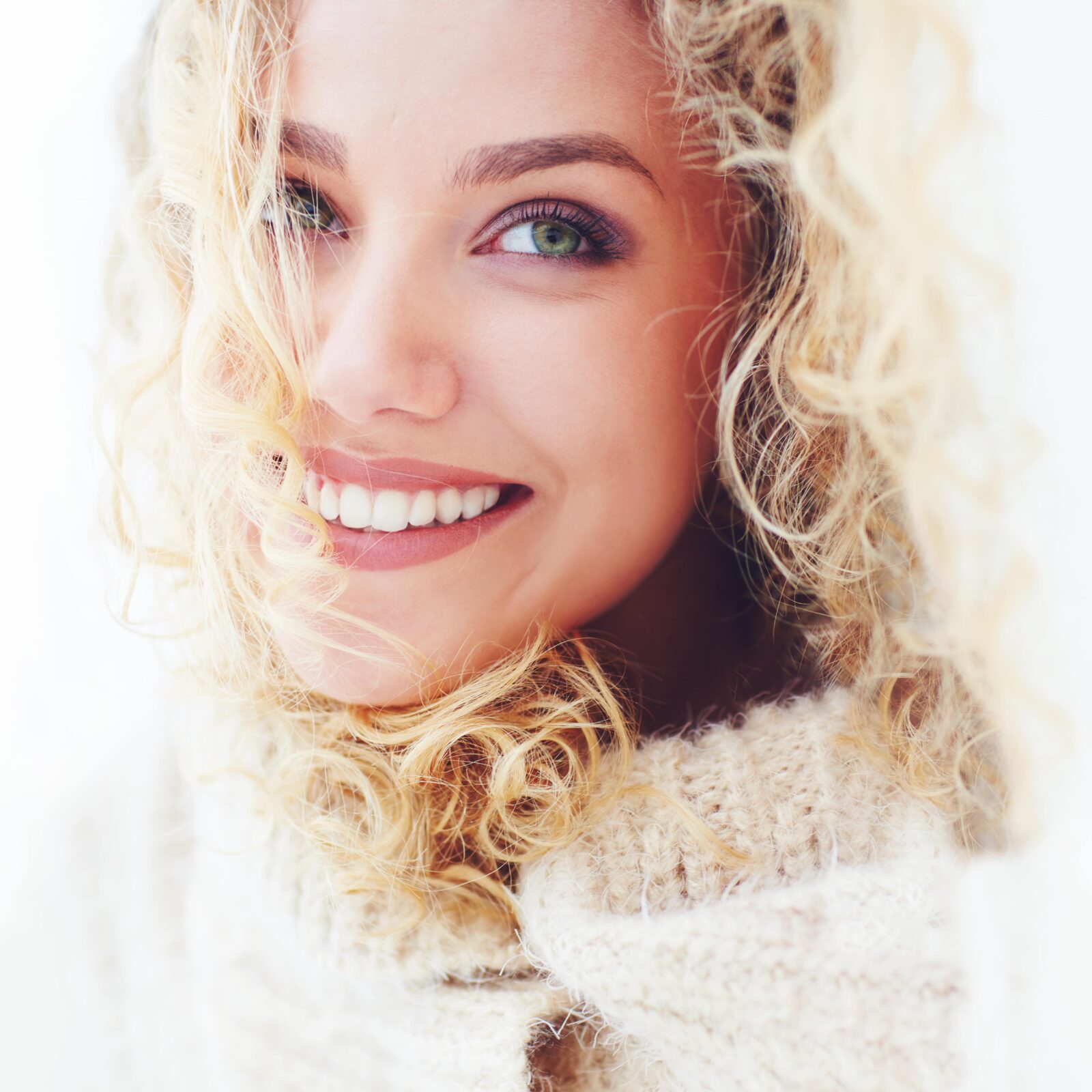 blonde woman smiling in sweater