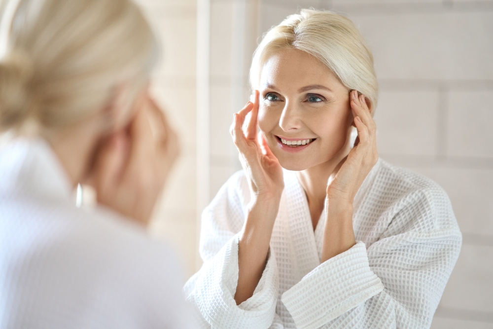 Woman looking at herself in the mirror after receiving a Exact RF treatment